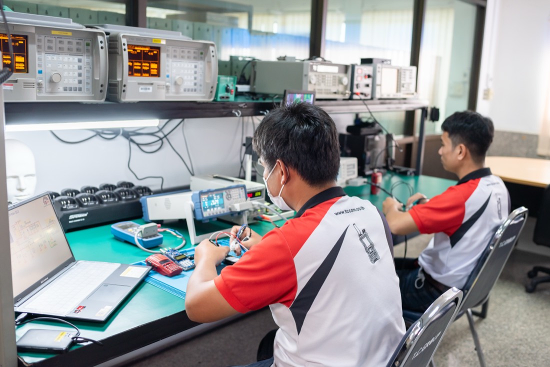 Engineers at R&D workbenches testing radios